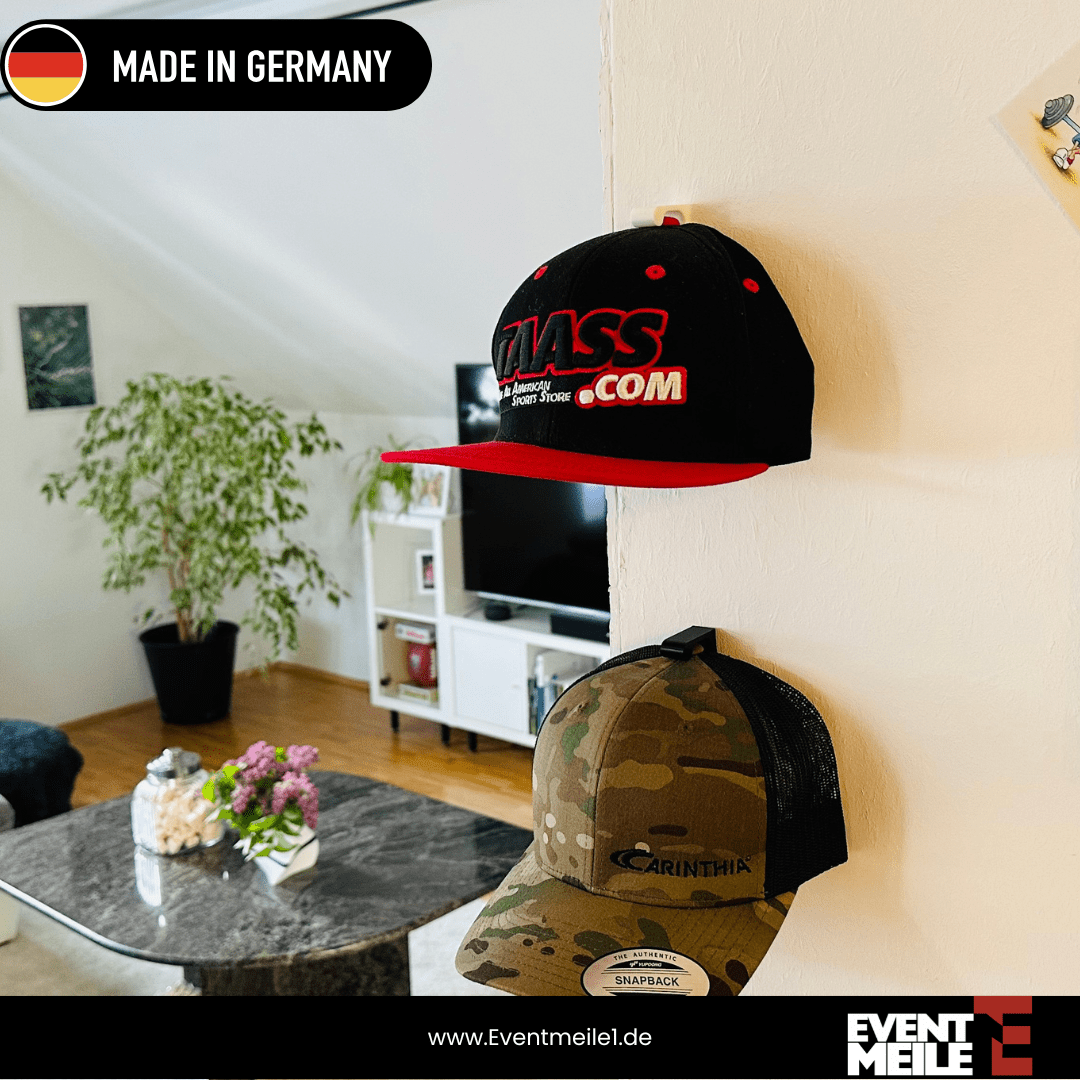 Zwei BaseCaps an NEXCAPE Cap-Wandhalterungen an einer Wohnzimmerwand – platzsparende Cap-Aufbewahrung im Wohnraum, Made in Germany